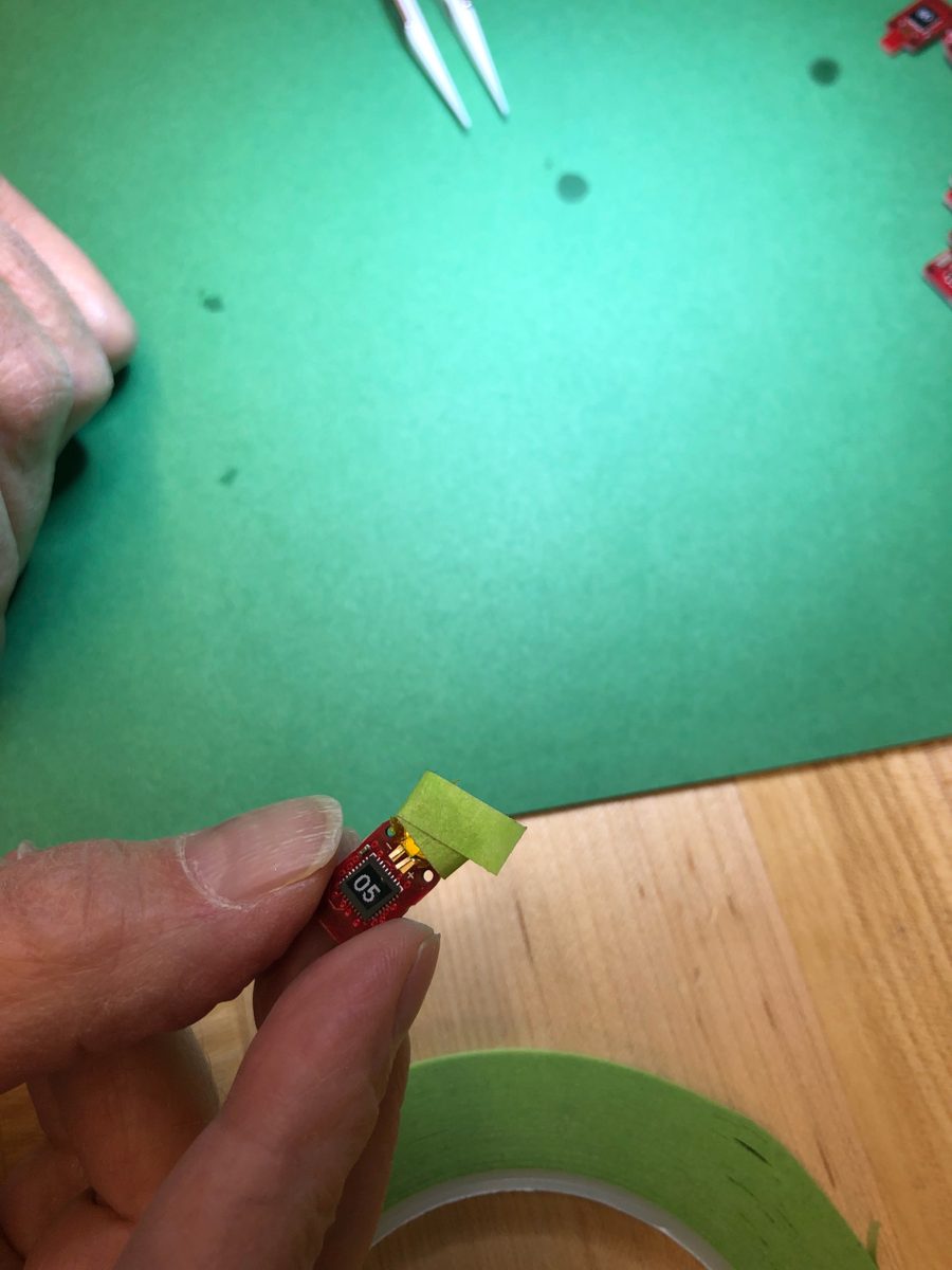 The tape folded over the back of the tag board to hold the battery in position