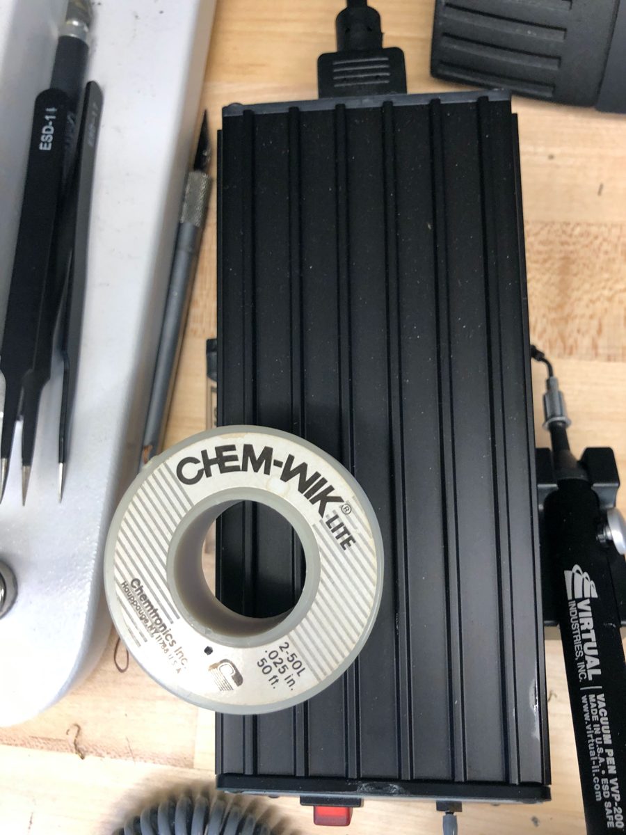 A roll of Chem-Wik Lite 0.025 inch solder wick beside ESD tweezers and a vacuum pen