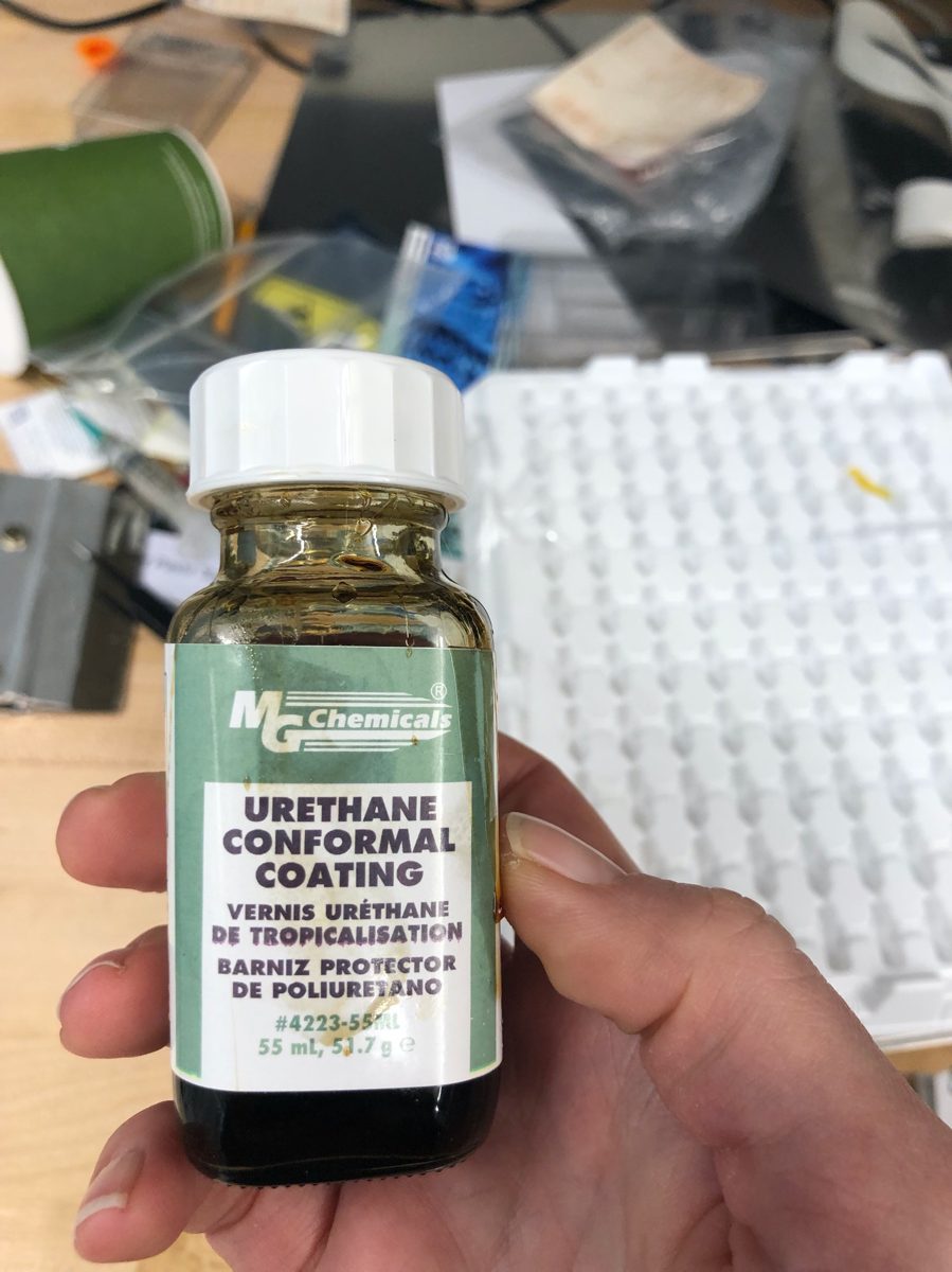 A bottle of MG Chemicals urethane conformal coating held in one hand